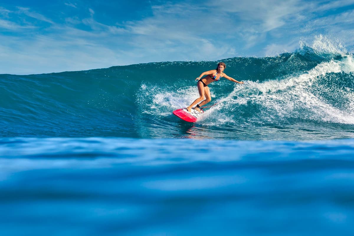 Surfer riding a perfect wave at Bali Beach