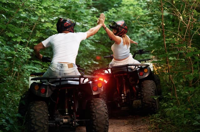 An ATV rider splashing through muddy trails