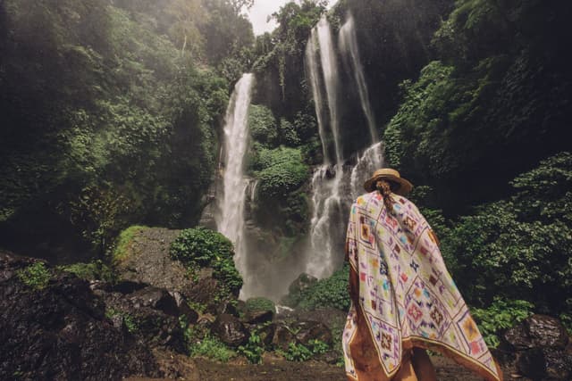 A traveler standing in front of Sekumpul Waterfall