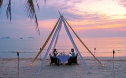 A couple having dinner on a secluded beach