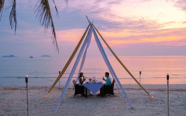 A couple having dinner on a secluded beach
